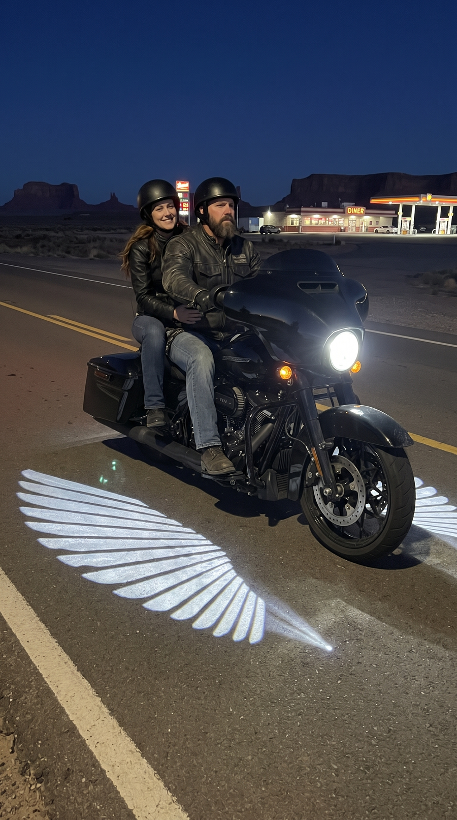 Couple on a bagger on a desert highway with wings lit